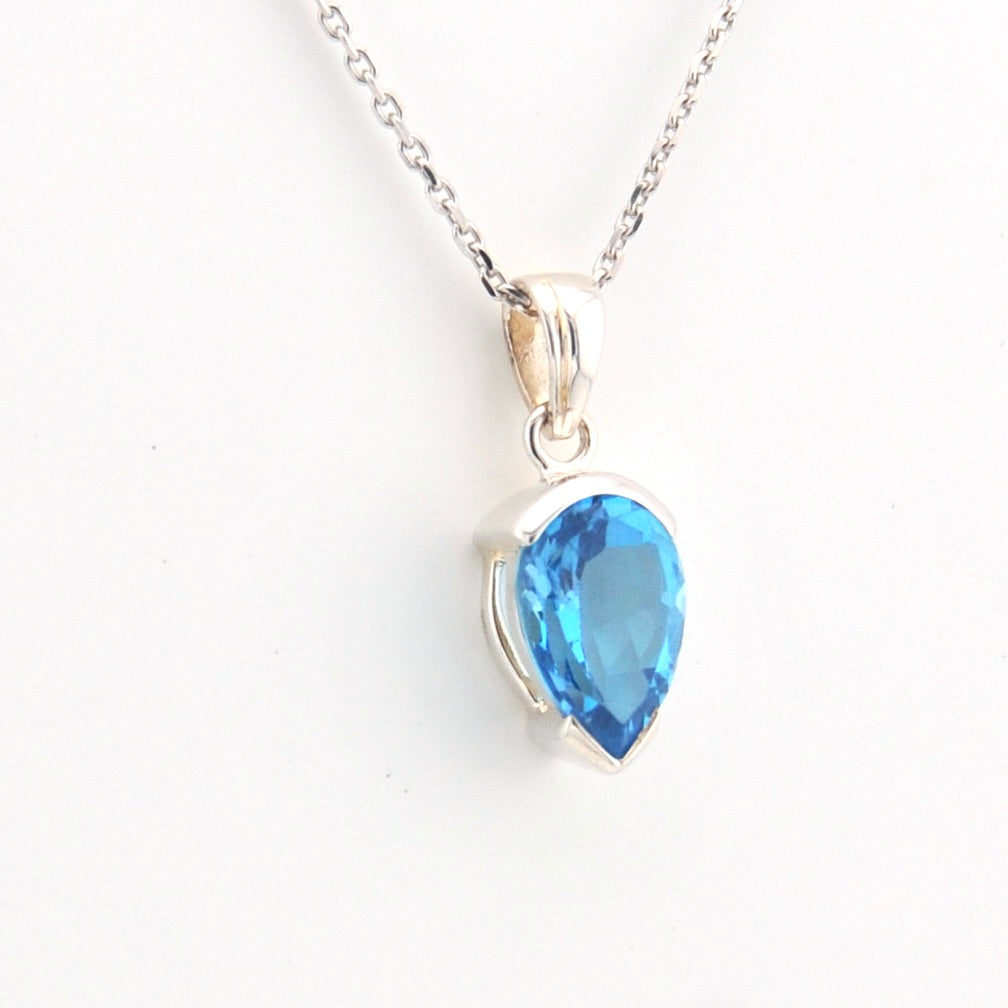 Blue teardrop pendant on a silver chain against a white background