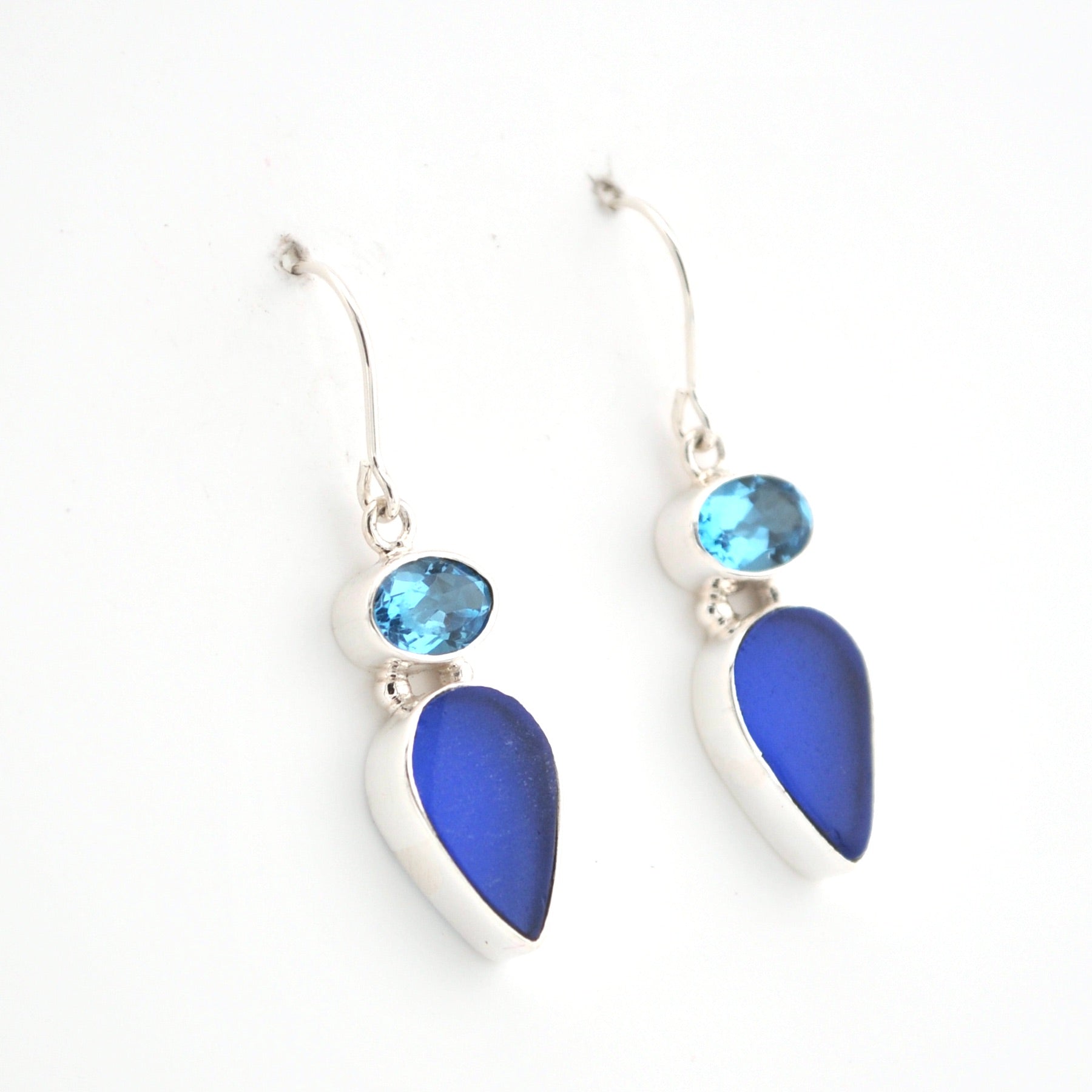 Pair of earrings with blue teardrop-shaped stones on a white background