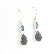 Pair of silver earrings with teardrop-shaped gemstones on a white background
