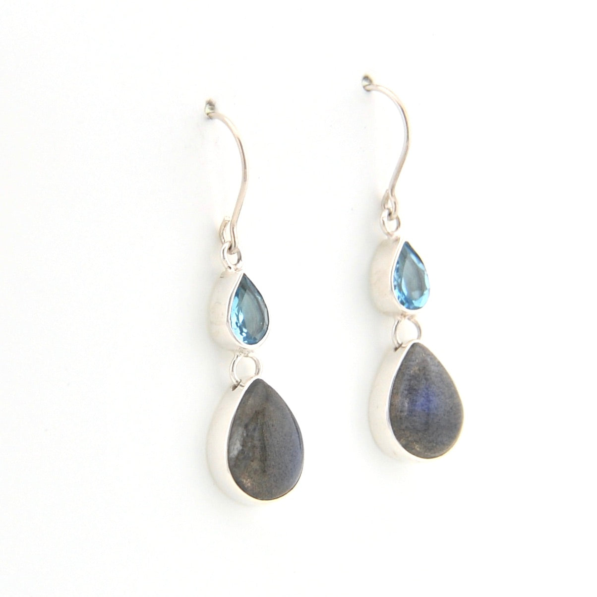 Pair of silver earrings with teardrop-shaped gemstones on a white background