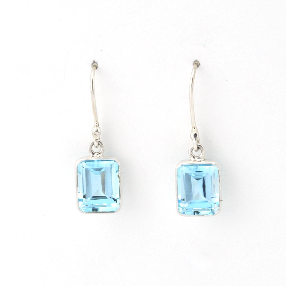 Pair of earrings with blue gemstones on a white background