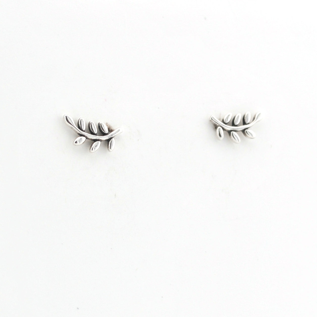 Pair of silver leaf-shaped earrings on a white background