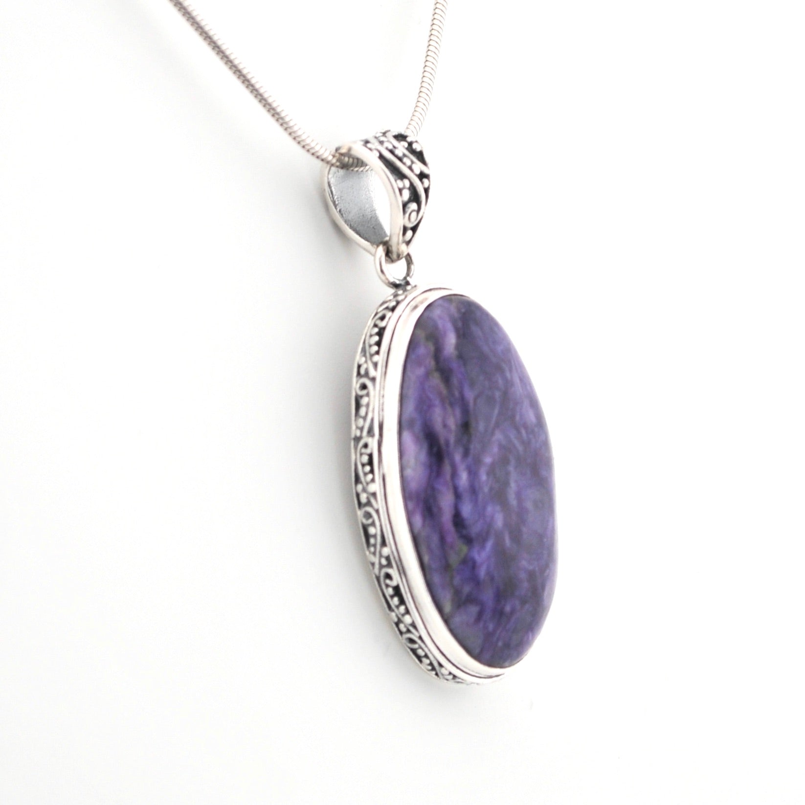 Purple oval pendant with silver frame on a white background