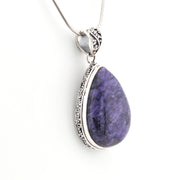 Purple teardrop pendant with silver frame on a white background