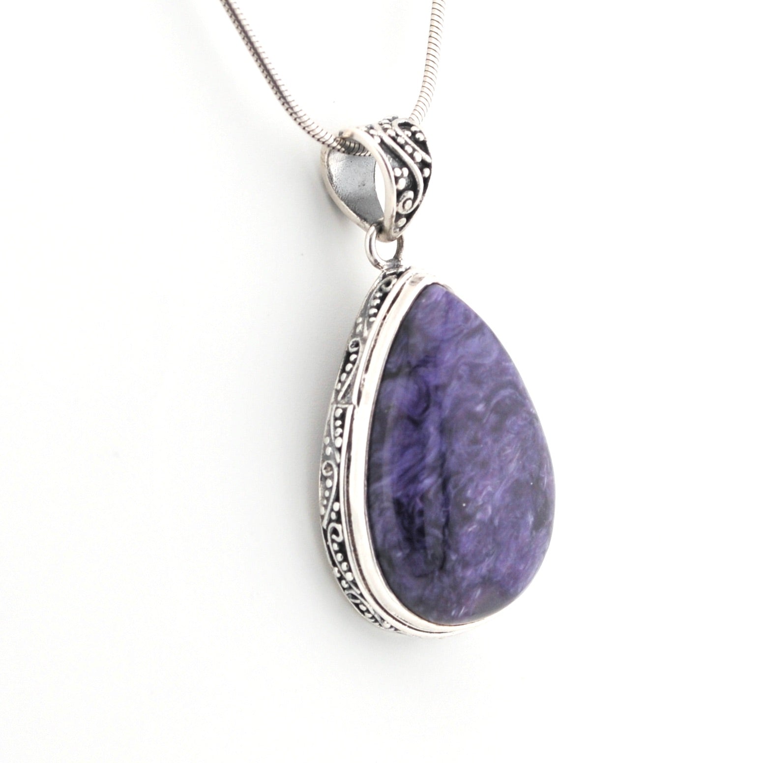 Purple teardrop pendant with silver frame on a white background