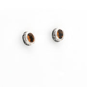 Pair of silver earrings with citrine stones on a white background