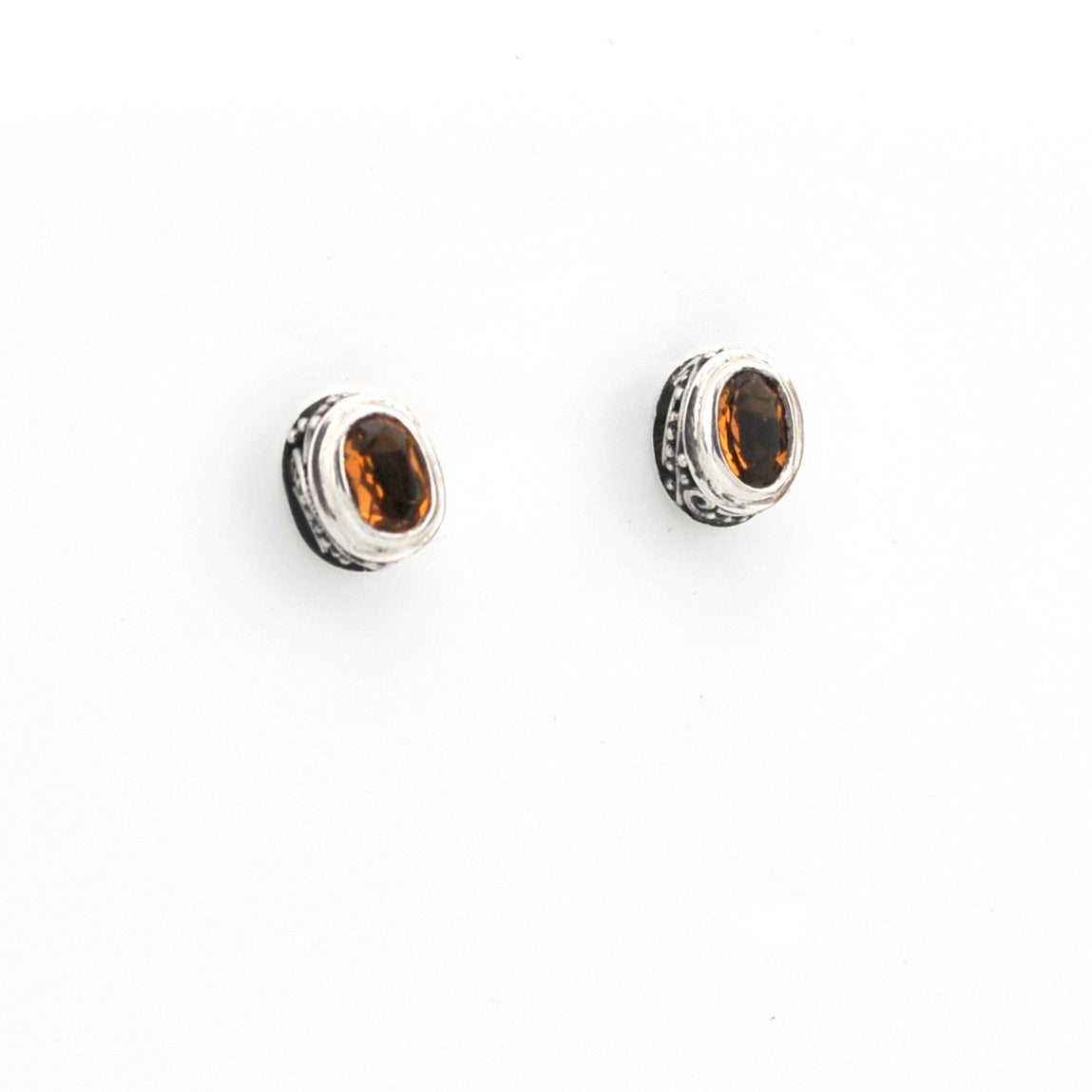 Pair of silver earrings with citrine stones on a white background