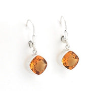 A pair of silver leverback earrings with cushion-cut amber-orange gemstones, shown on a plain white background.