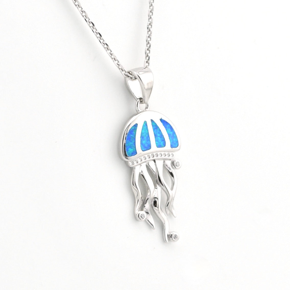 Jellyfish-shaped pendant with blue opal inlay on a white background