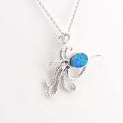 Silver octopus pendant with a blue opal stone on a white background
