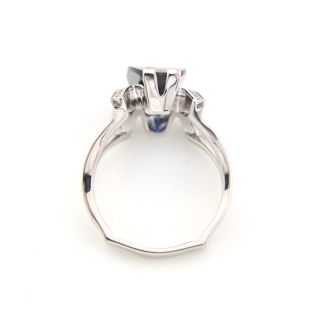 Silver ring with a large central stone on a white background
