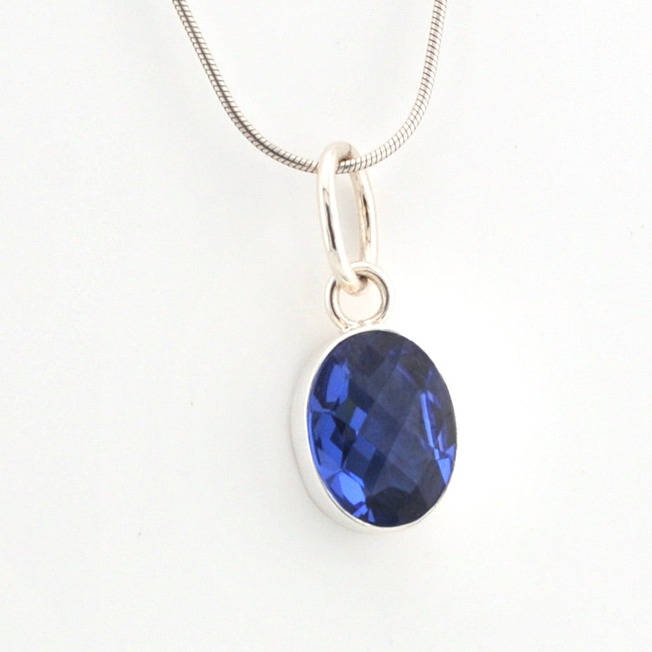 Blue gemstone pendant on a white background
