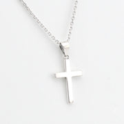 Silver cross pendant on a chain against a white background