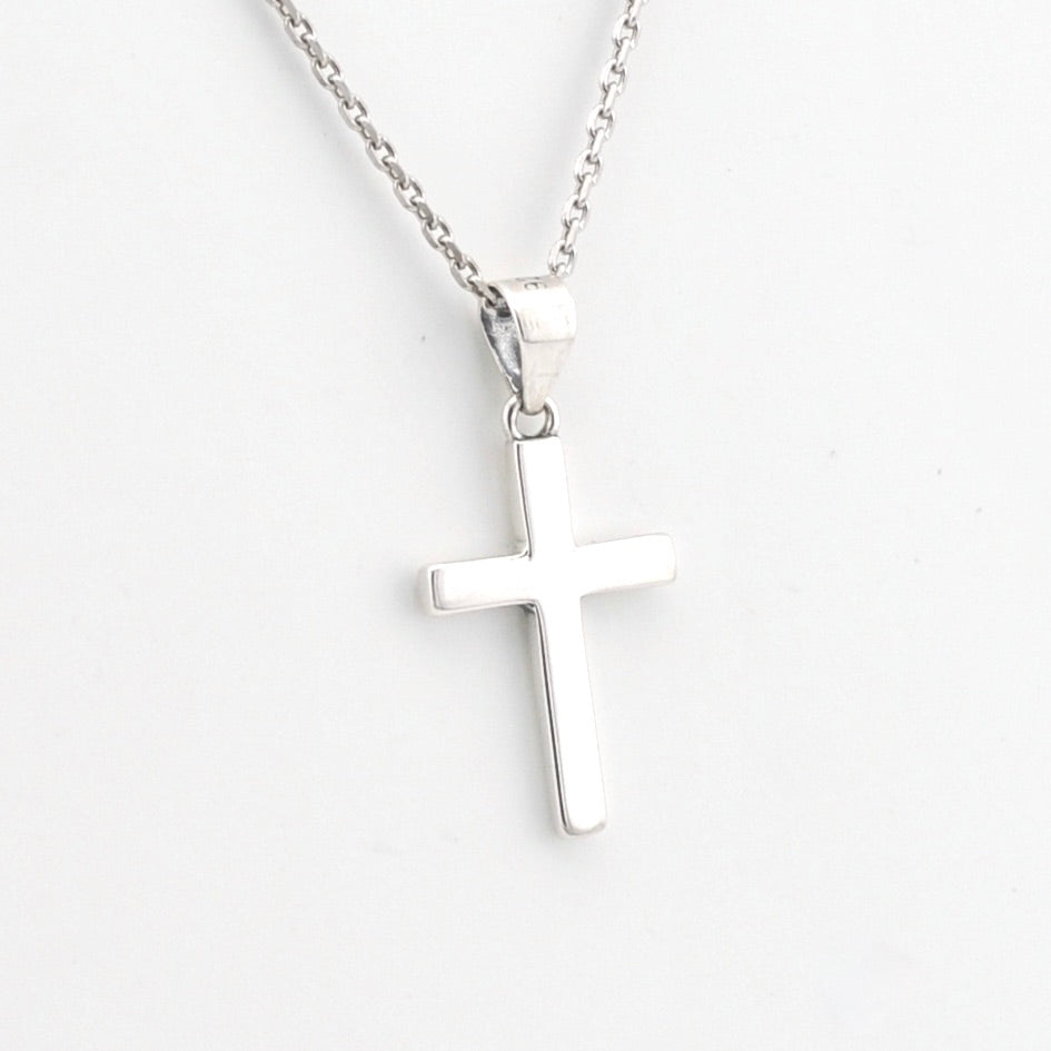 Silver cross necklace on a white background
