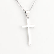 Silver cross pendant on a chain against a white background