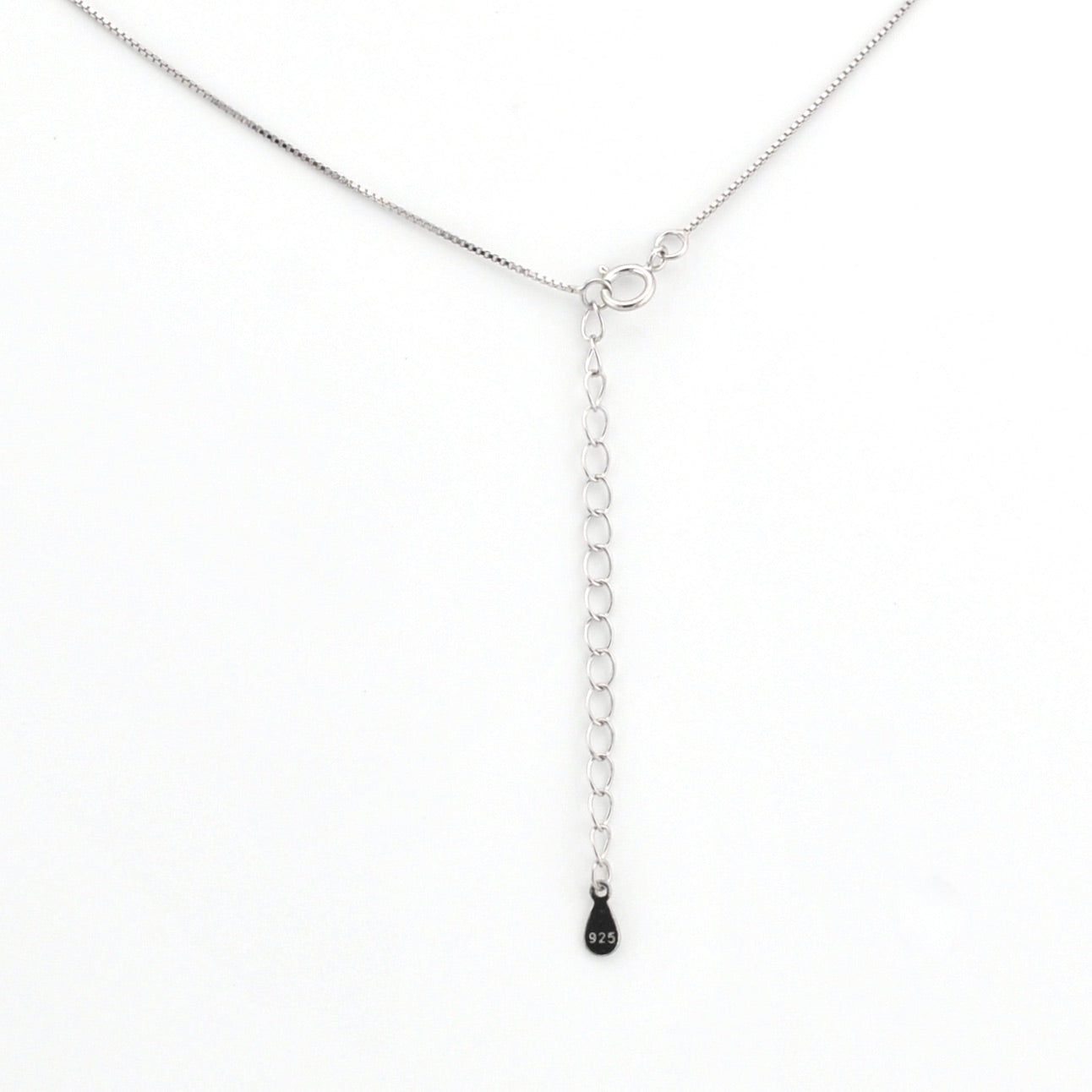 Silver chain necklace with a small black pendant on a white background