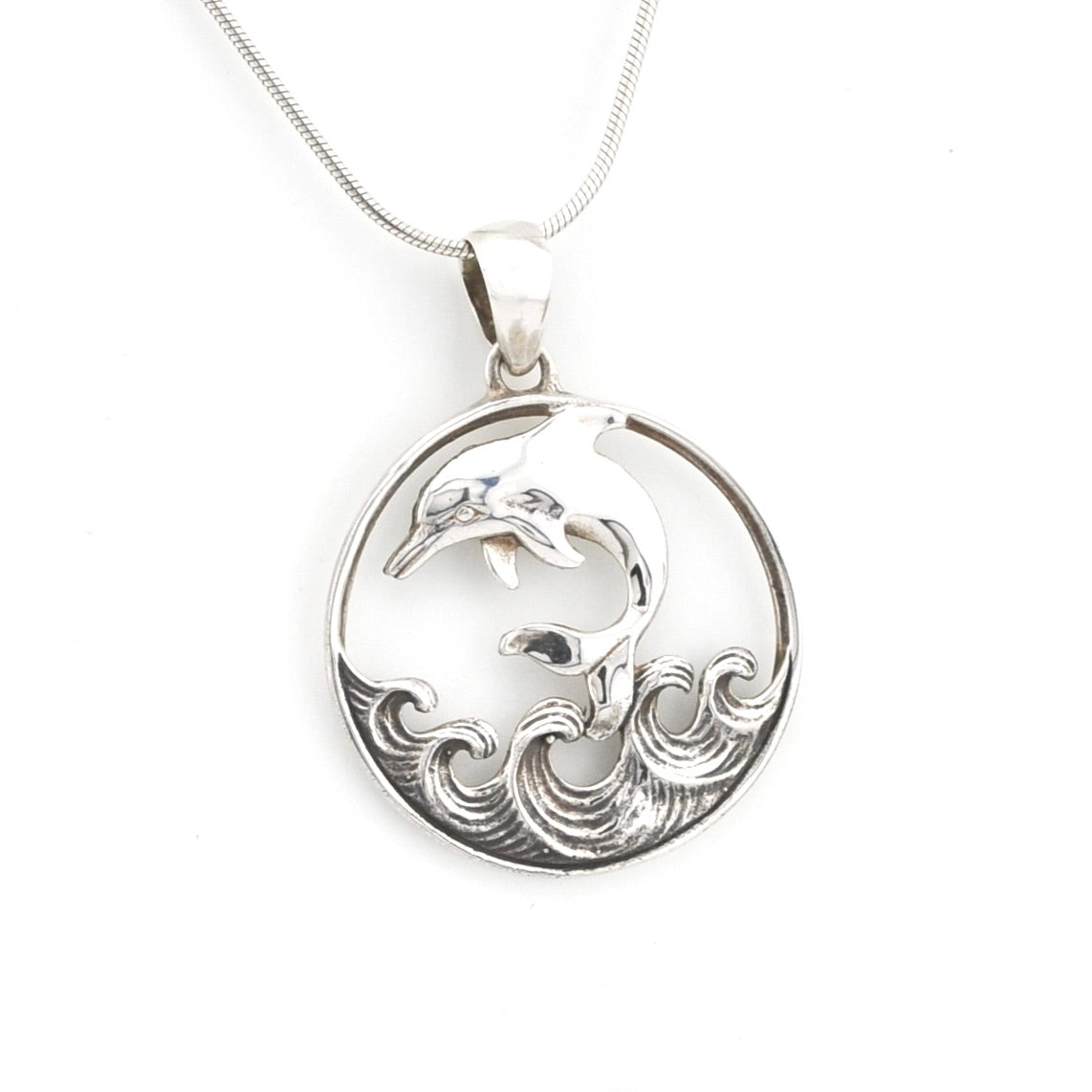 Silver pendant with dolphin design on a white background