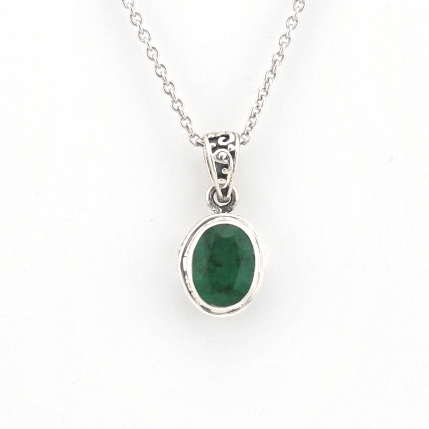 Silver necklace with a green gemstone pendant on a white background