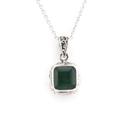 Silver pendant with a green gemstone on a white background