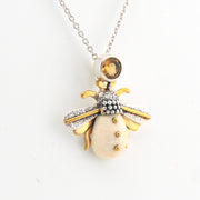 Jewelry pendant shaped like a bee on a white background