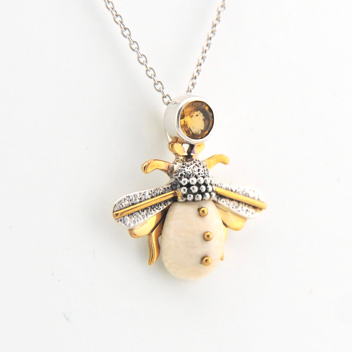Jewelry pendant shaped like a bee on a white background