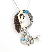 Mermaid pendant necklace with blue gemstones on a white background