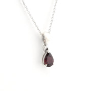 A silver pendant necklace featuring a teardrop-shaped dark red gemstone, shown against a plain white background.