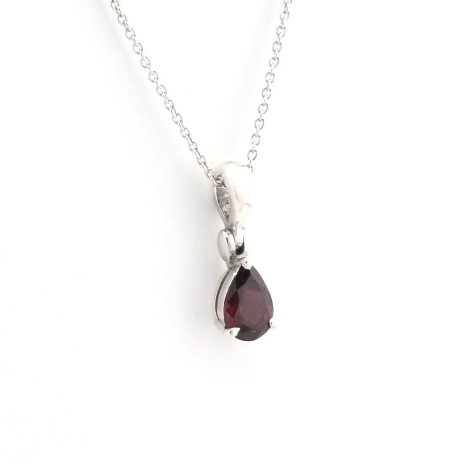 A silver pendant necklace featuring a teardrop-shaped dark red gemstone, shown against a plain white background.