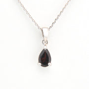 Teardrop-shaped gemstone pendant on a silver chain against a white background
