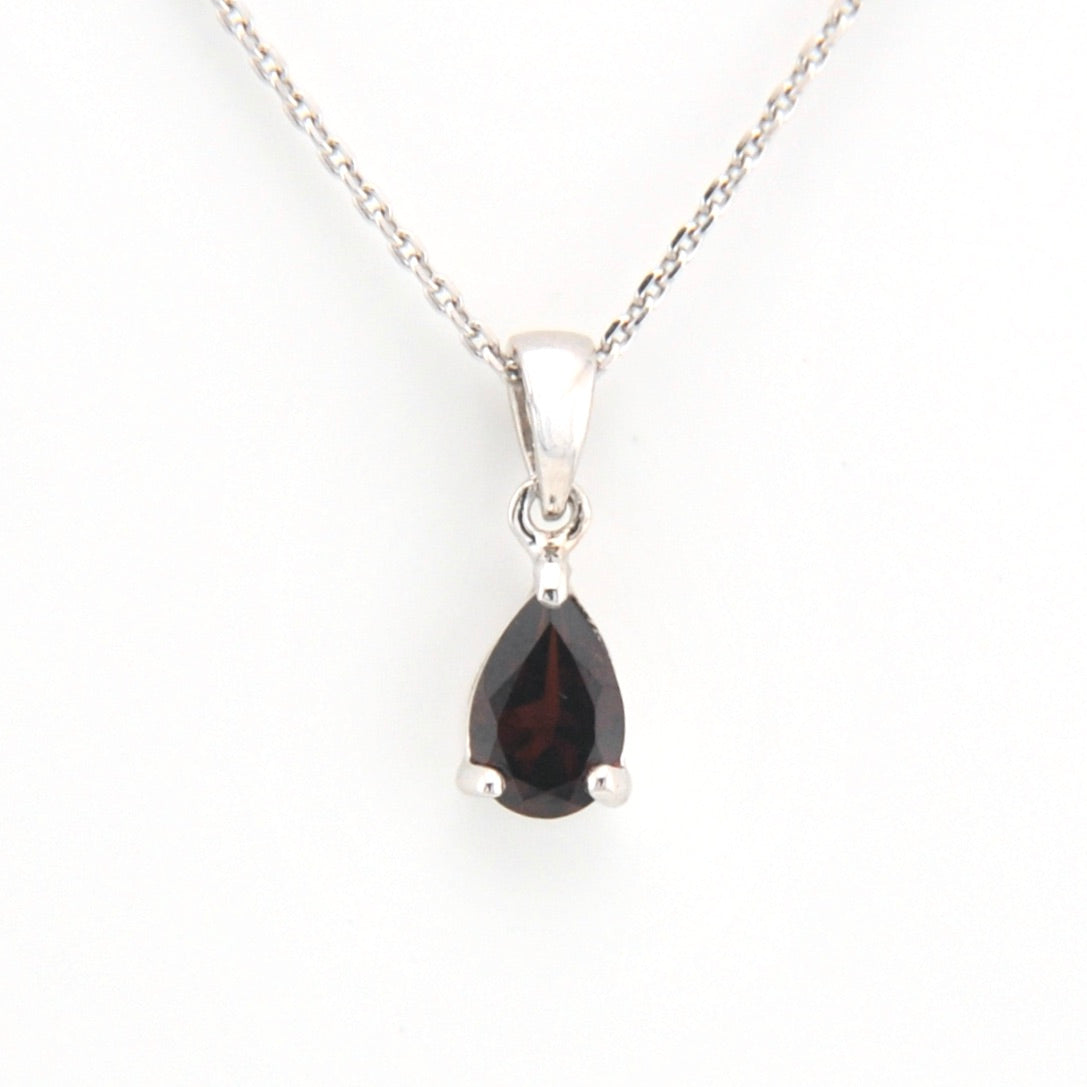 Teardrop-shaped gemstone pendant on a silver chain against a white background