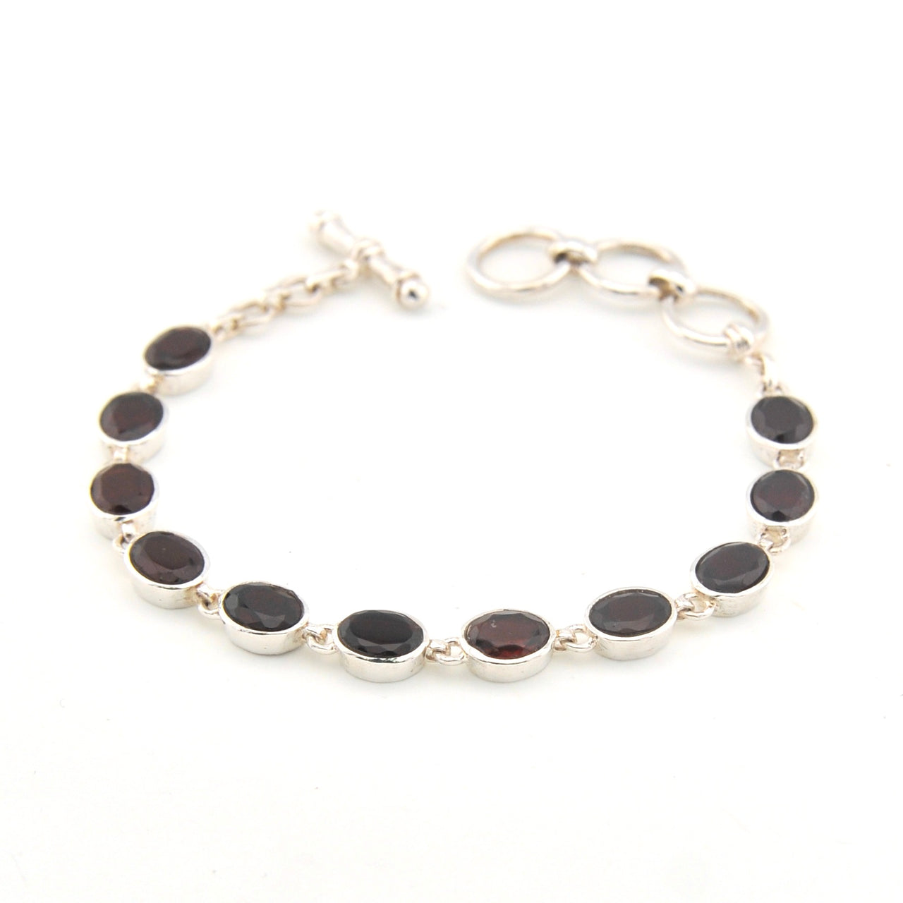 Silver bracelet with garnet oval on a white background