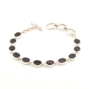 Silver bracelet with garnet oval on a white background