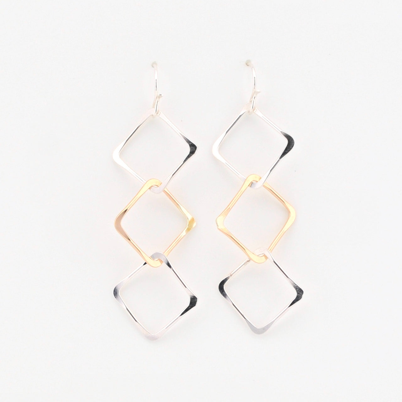 Gold and silver geometric earrings on a white background