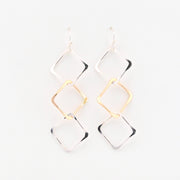 Gold and silver geometric earrings on a white background