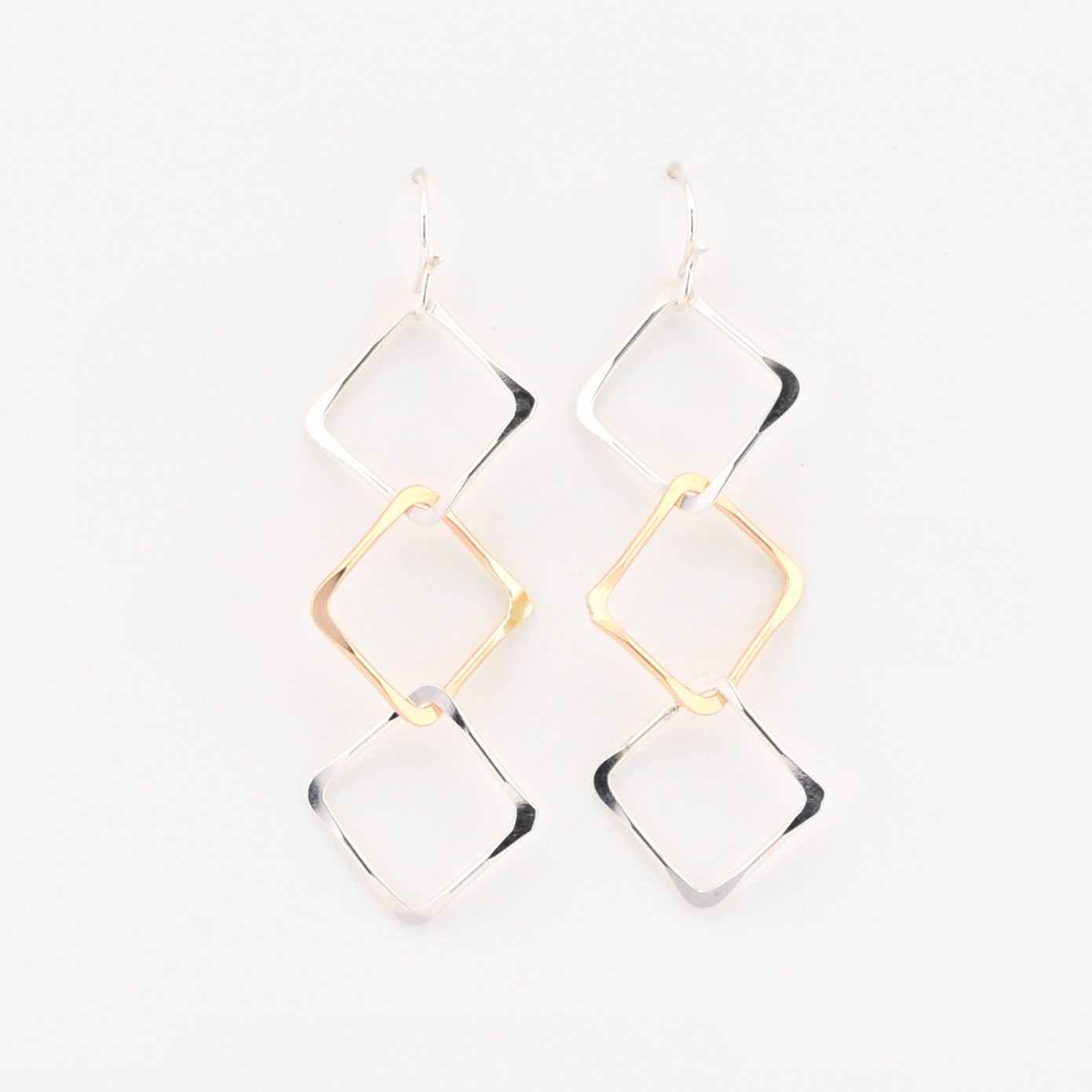 Gold and silver geometric earrings on a white background