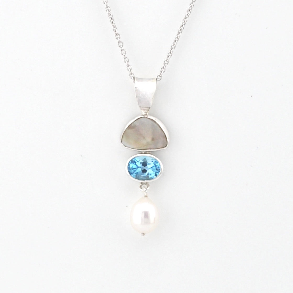 Necklace with pendant featuring a blue gemstone and pearl on a white background