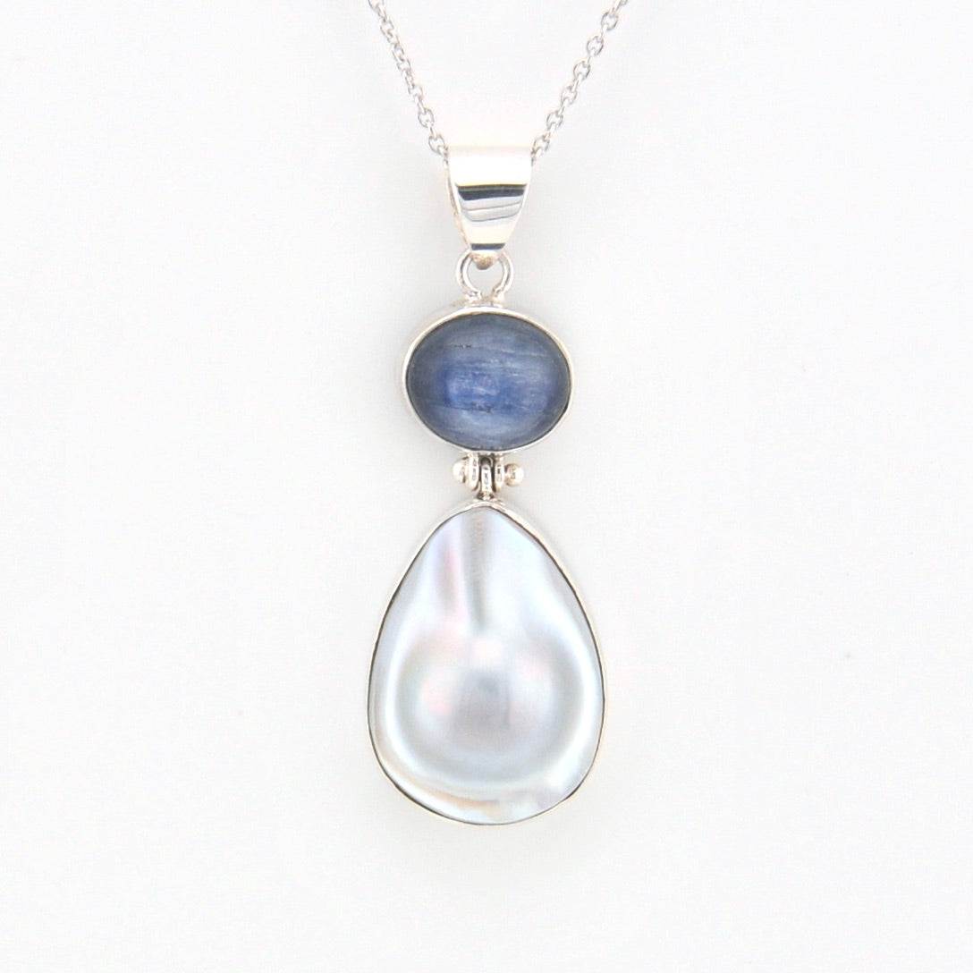 Necklace with a teardrop-shaped pearl and blue kyanite gemstone on a white background