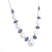A silver-toned beaded necklace featuring alternating polished blue oval-shaped stones and irregular white keshi pearls, displayed on a clean white background.