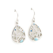 Silver earrings with starfish and blue gemstone design on a white background