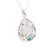 Silver pendant with tear design and blue stones on a white background