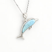 Dolphin pendant with larimar on a silver chain on white background.