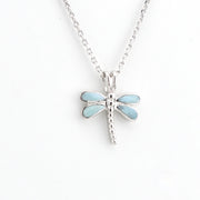 Dragonfly-shaped pendant on a chain against a white background