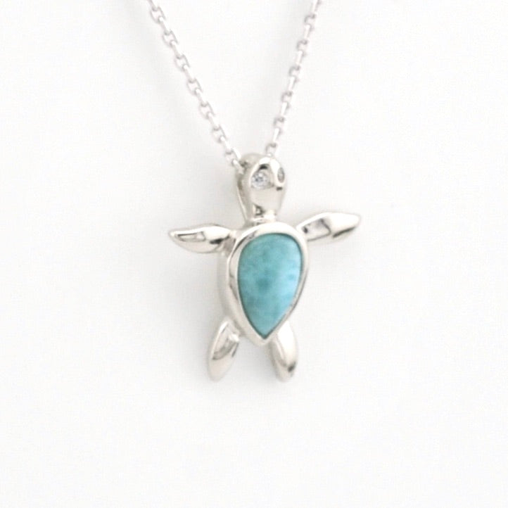 Silver turtle pendant with a blue stone on a white background