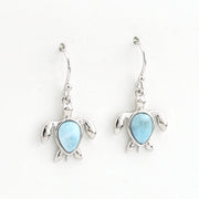 Turtle-shaped earrings with blue gemstones on a white background
