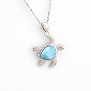 Silver turtle pendant with a blue stone on a white background