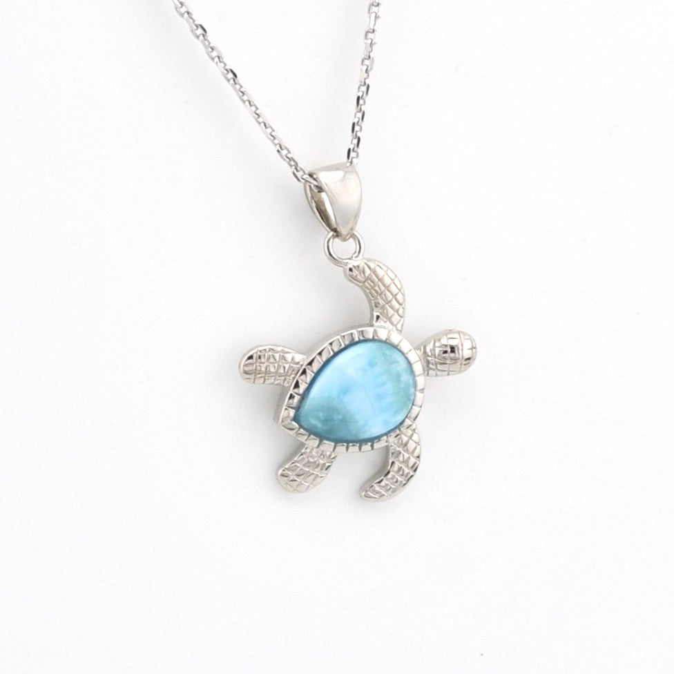 Silver turtle pendant with a blue stone on a white background