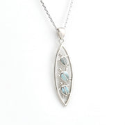 Silver pendant with a light blue gemstone on a white background