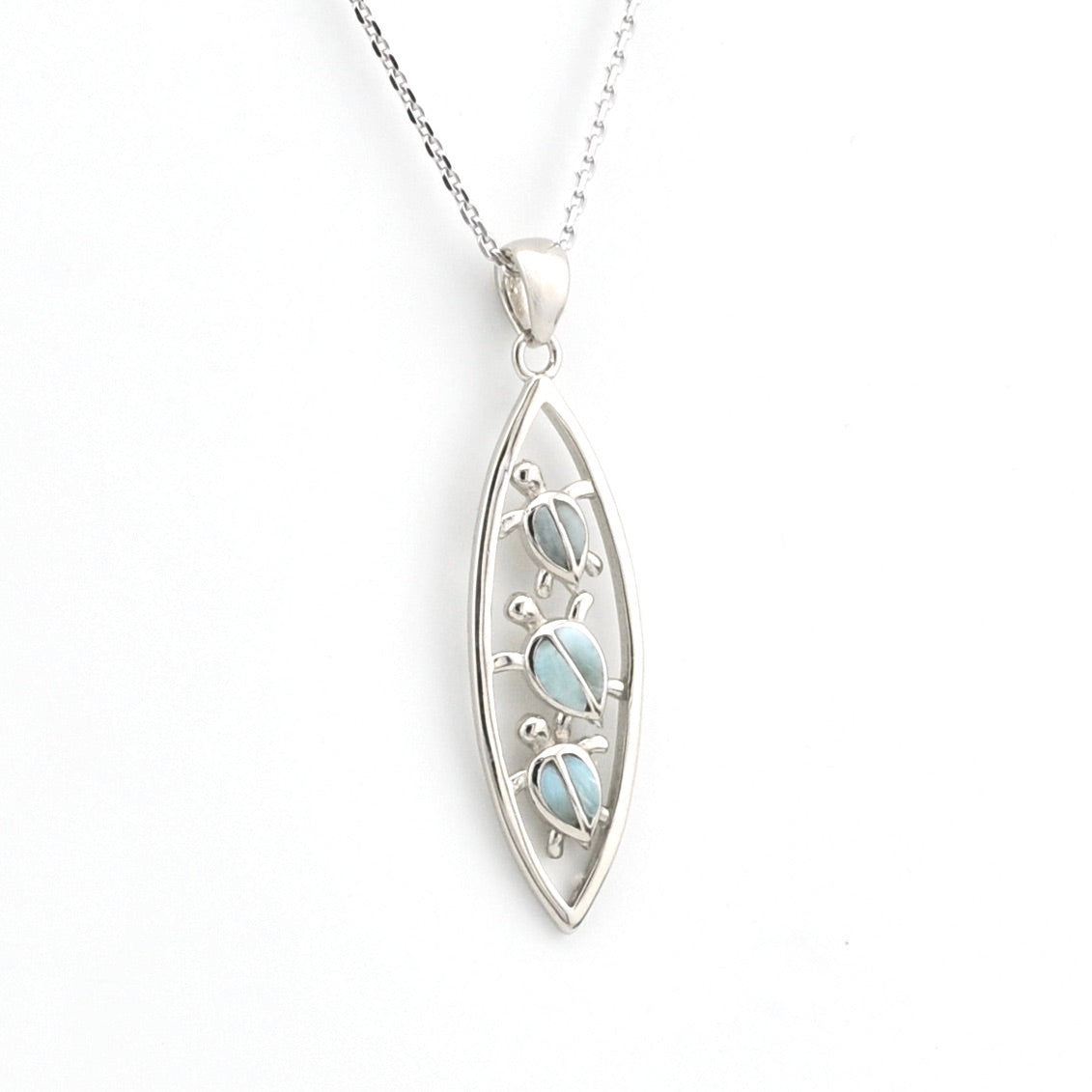 Silver pendant with a light blue gemstone on a white background