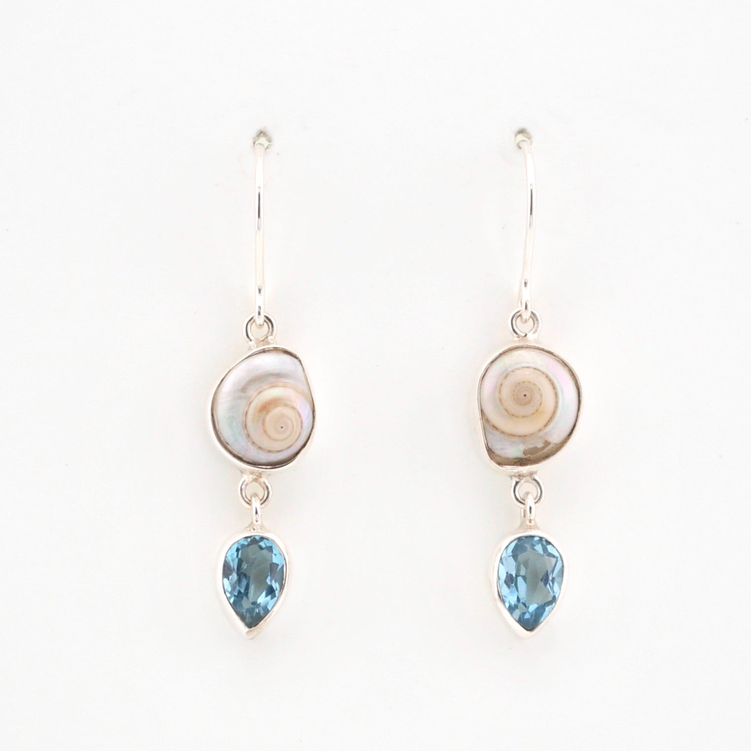 Pair of earrings with shell and blue gemstone drops on a white background