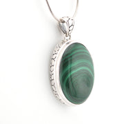 Green stone pendant with silver setting on a white background